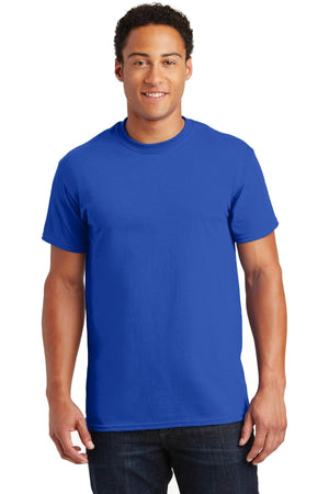A person wearing a Gildan - 100% US Cotton T-Shirt 2000 in plain blue and dark jeans stands against a white background.