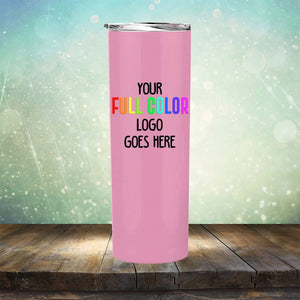 A pink Custom UV Printed Drinkware - ONE TIME SPECIAL OFFER by Kodiak Coolers with the text "YOUR FULL COLOR LOGO GOES HERE" engraved on it, placed on a wooden surface against a blurry background.