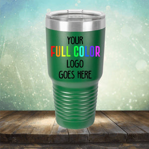 A green Custom UV Printed Drinkware - ONE TIME SPECIAL OFFER from Kodiak Coolers with the text "Your Full Color Logo Goes Here" on it, placed on a wooden surface with a blurred light background, offers an excellent canvas for custom engraving.