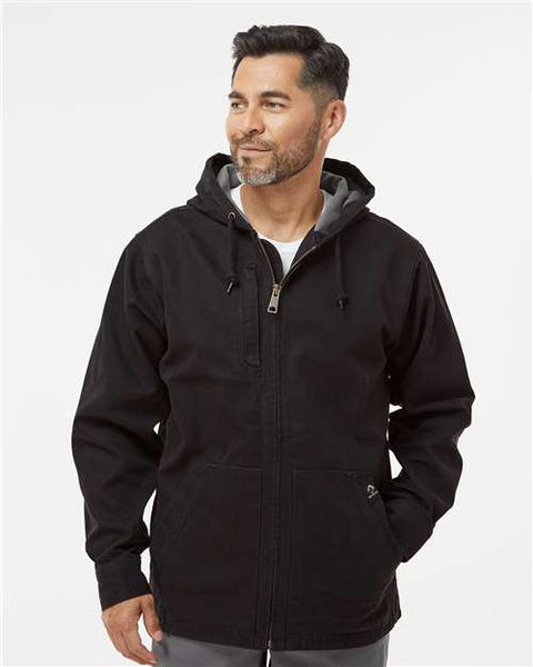 A man wearing a DRI DUCK Laredo Boulder Cloth Canvas Jacket with Thermal Lining made of heavyweight cotton with wind resistance.