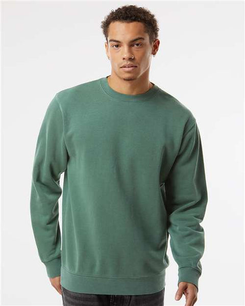 A man wearing a customized green Independent Trading Co. Midweight Pigment-Dyed Crewneck Sweatshirt by Independent Trading Co.