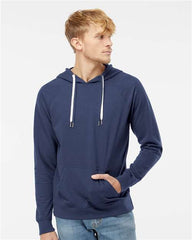 A man wearing a blue Independent Trading Co Icon Unisex Lightweight Loopback Terry Hoodie Sweatshirt branded with the company logo and jeans.