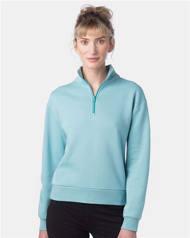 A person with curly hair is wearing a light blue 