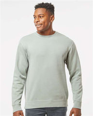 A man wearing a green Independent Trading Co. Midweight Pigment-Dyed Crewneck Sweatshirt and jeans.