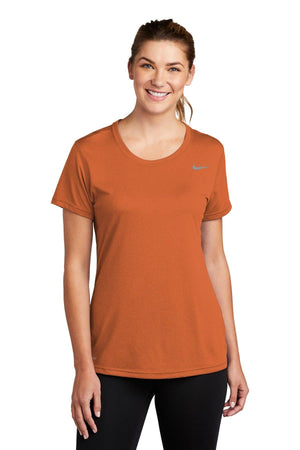 Woman wearing an orange Nike Ladies Legend T-Shirt CU7599 with Dri-FIT technology and black pants.