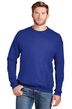 A man wearing a Hanes Ultimate 100% Cotton Crewneck Sweatshirt F260 in blue and blue jeans stands facing forward with one hand in his pocket.