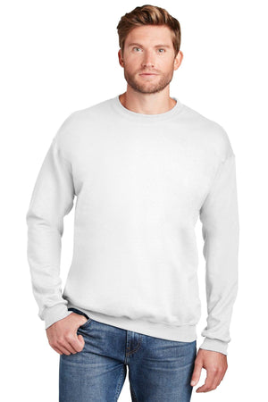 A man stands against a white background wearing a Hanes Ultimate 100% Cotton Crewneck Sweatshirt F260 in plain white and blue jeans, with one hand in his pocket.