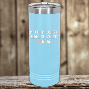 A light blue Kodiak Coolers stainless steel tumbler with a silver lid, engraved with your custom company logo—perfect as Realtor closing gifts for clients—shown on a wooden surface with a blurred wood background.