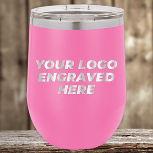 A pink insulated tumbler by Kodiak Coolers, engraved with your custom company logo, sits on a wooden surface—ideal as Realtor closing gifts for clients or personalized promotional drinkware.