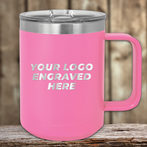 A pink Kodiak Coolers mug with handle and clear lid, engraved with "YOUR LOGO ENGRAVED HERE," sits on wood—a perfect Realtor Closing Gift for clients seeking custom company logo drinkware.