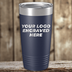 A navy blue Kodiak Coolers tumbler with a silver lid rests on a wooden surface, featuring "YOUR LOGO ENGRAVED HERE"—the perfect Realtor closing gift for clients with your custom company logo on drinkware.
