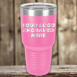 A pink Kodiak Coolers insulated tumbler with a silver lid, engraved with your custom company logo—ideal as Realtor closing gifts for clients or to enhance your custom mug collection. Displayed on a wooden surface with a blurred wood background.