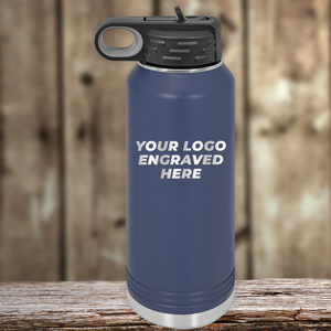 A blue stainless steel water bottle by Kodiak Coolers sits on a wooden surface, featuring your custom company logo—an ideal Realtor closing gift to pair with personalized mugs for clients.