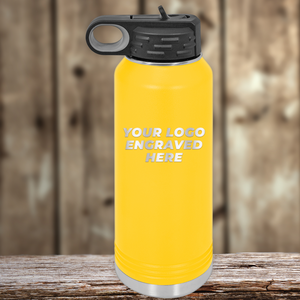 A yellow Kodiak Coolers water bottle with a black lid sits on wood, featuring "YOUR LOGO ENGRAVED HERE" in bold white letters—a perfect Realtor closing gift option paired with custom mugs for clients.