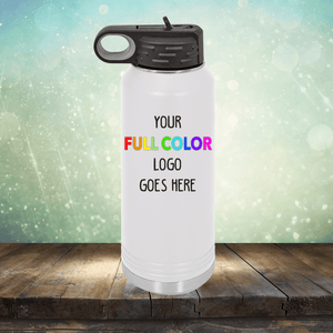 A white reusable water bottle with a black lid is displayed with the text "Your Full Color Logo Goes Here" printed on its front. The background features a blurred, light-filled design. Perfect for pairing with our customizable coffee mugs and tumblers, the Kodiak Coolers Custom UV Printed Drinkware - ONE TIME SPECIAL OFFER can also feature precise engraving for added elegance.