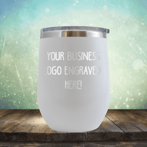 Stainless steel tumbler from Kodiak Coolers with custom logo promotional gift engraving space on wooden surface against a bokeh background.