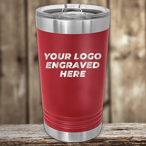 The Kodiak Coolers Realtor Closing Gifts for Clients tumbler features your custom company logo engraved in white on red insulated drinkware with a clear lid—ideal for personalized or custom logo mugs, displayed on a wooden surface.