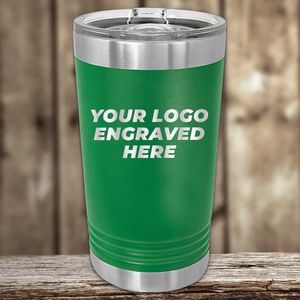 A green Kodiak Coolers tumbler with a clear lid displays "Your Custom Company Logo Engraved" on the front. Perfect as a Realtor closing gift for clients, it sits on wood with a blurred wooden background.