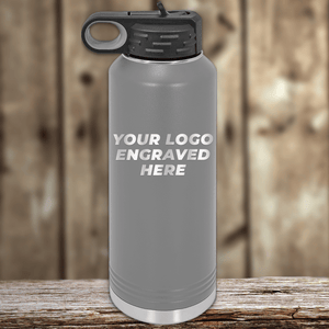 A gray metal water bottle with a black lid by Kodiak Coolers, custom-engraved with your company logo—ideal realtor closing gift drinkware to pair with your branded mugs.
