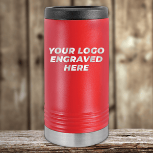 A red insulated Kodiak Coolers tumbler with a black lid, silver base, and your custom company logo engraved on the front—Realtor Closing Gifts for Clients—sits on a wooden surface with a blurred wood background.