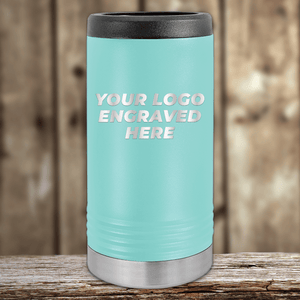 A light blue Kodiak Coolers tumbler with black lid and silver base, engraved with your company logo, makes the perfect Realtor closing gift—custom promotional drinkware for clients—displayed on wood with a blurred background.