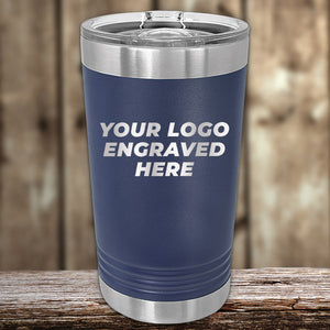 Navy blue stainless steel Custom Pint Tumblers 16 oz with Slider Lid by Kodiak Coolers displayed on a wooden surface.