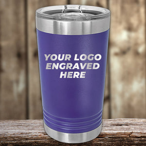 A purple Custom Pint Tumbler 16 oz with your Logo or Design Engraved by Kodiak Coolers displayed on a wooden surface.