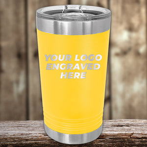 Yellow insulated Custom Pint Tumbler 16 oz with Slider Lid by Kodiak Coolers, with customizable engraving space on wooden surface and double-walled insulation.