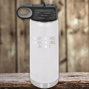 A Kodiak Coolers custom white water bottle with an engraved logo sitting on a wooden table.