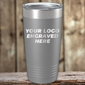 Stainless steel Custom Tumblers 20 oz with your Logo or Design Engraved - Special Bulk Wholesale Pricing by Kodiak Coolers displayed on a wooden surface.