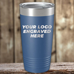 Blue insulated tumbler with "your logo engraved here" text, displayed on a wooden surface against a blurred background, ideal for corporate promotional gifts by Kodiak Coolers.