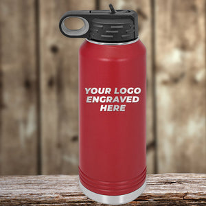 A red Kodiak Coolers bottle with a black lid rests on wood, featuring “YOUR LOGO ENGRAVED HERE.” This Engraved Custom Logo Drinkware includes single side engraving in the price and offers bulk tiered pricing—ideal for brand promotions.