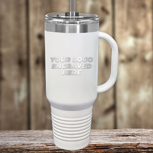 A promotional gift, a Custom 40 oz Travel Tumbler with Built in Handle and Straw - Stainless Steel - Special Bulk Wholesale Volume Pricing by Kodiak Coolers, sitting on a wooden table.